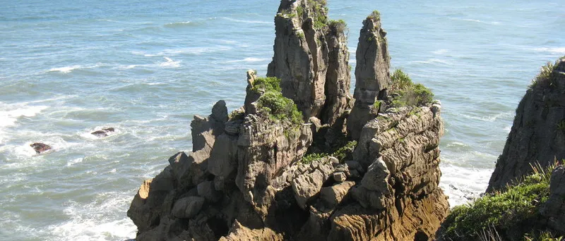Felsnadel aus geschichtetem Kalkstein in der Brandung von Punakaiki