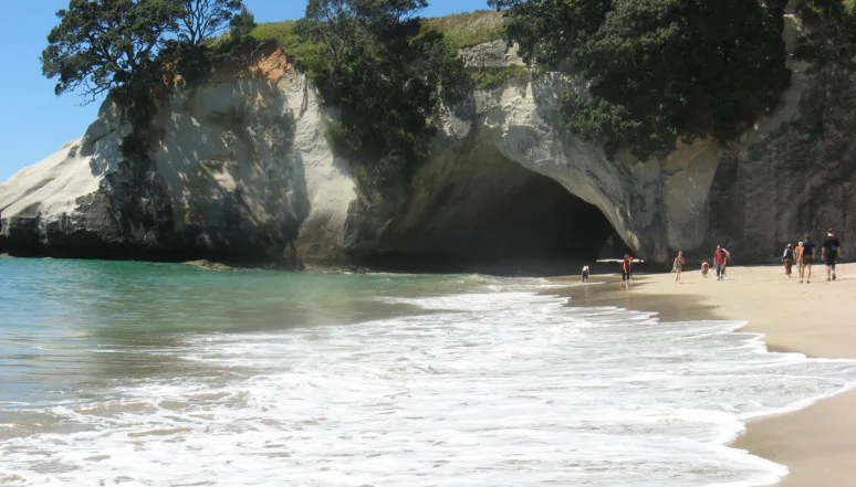 Der Felsdurchgang von Cathedral Cove hinter der auslaufenden Brandung