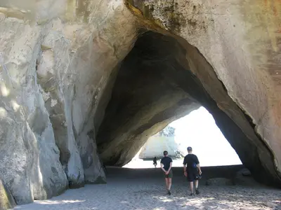 Menschen unter dem hohen Felsbogen von Cathedral Cove