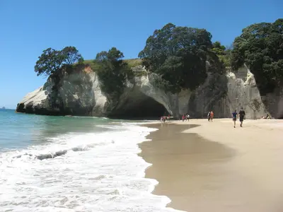 Strand von Cathedral Cove mit der Felsnadel im Wasser