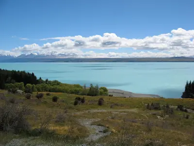 Der türkisfarbene Lake Pukaki mit Bergen am Horizont