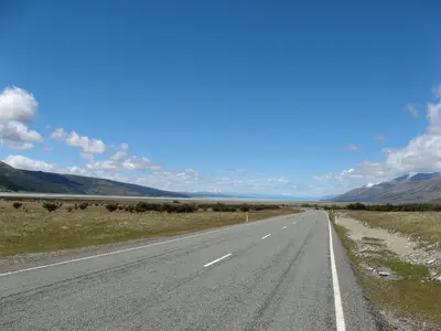 Gerade Straße durch das Tal auf die Berge zu