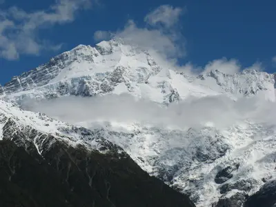 Gletscherbedeckte Bergflanke unter Wolken