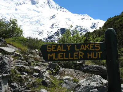 Wegweiser „Sealy Lakes / Mueller Hut“ vor den Bergen