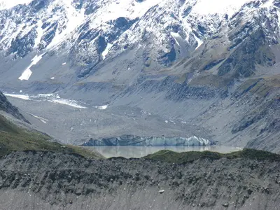 Zerfurchte Gletscheroberfläche vor Schneegipfeln
