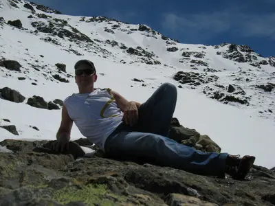 Rast auf einem Felsen mitten im Schneefeld