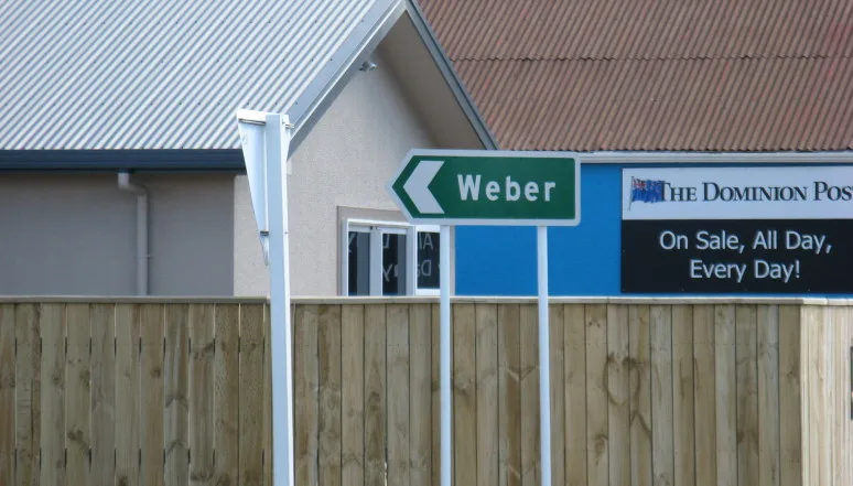 Grüner neuseeländischer Straßenwegweiser mit der Aufschrift „Weber“ vor einem Gebäude